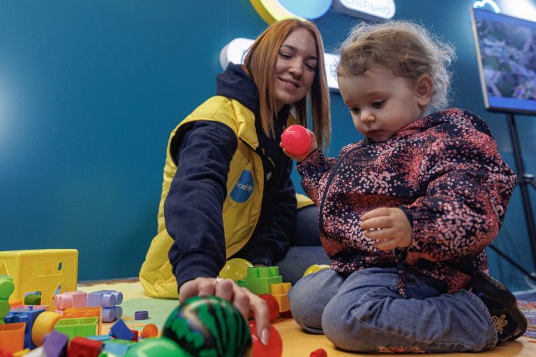 UNICEF-ova sodelavka se igra z otrokom iz Ukrajine.