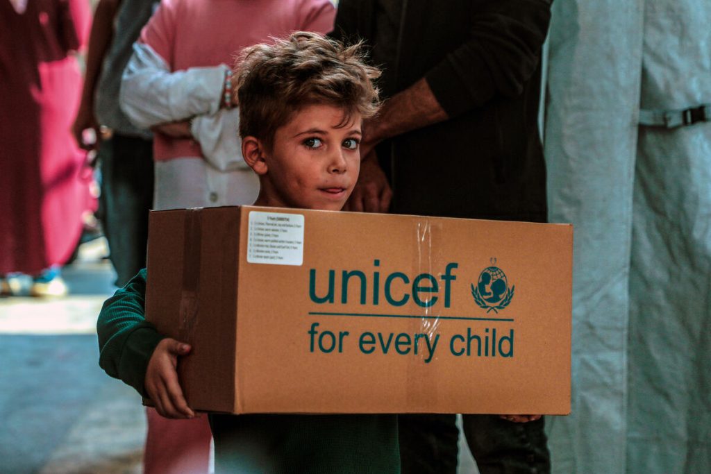 Deček s škatlo polno toplih zimskih oblek.