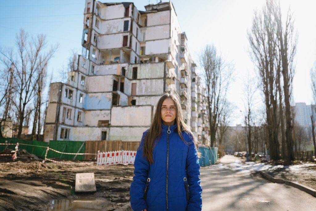18-letna Viktoria stoji ob visokem stolpnici v Kijevu, ki jo je uničil raketni napad.