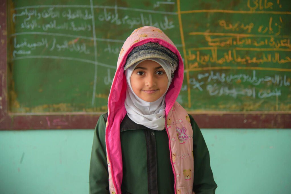 Deklica v učilnici v šoli v Jemnu stoji pred tablo