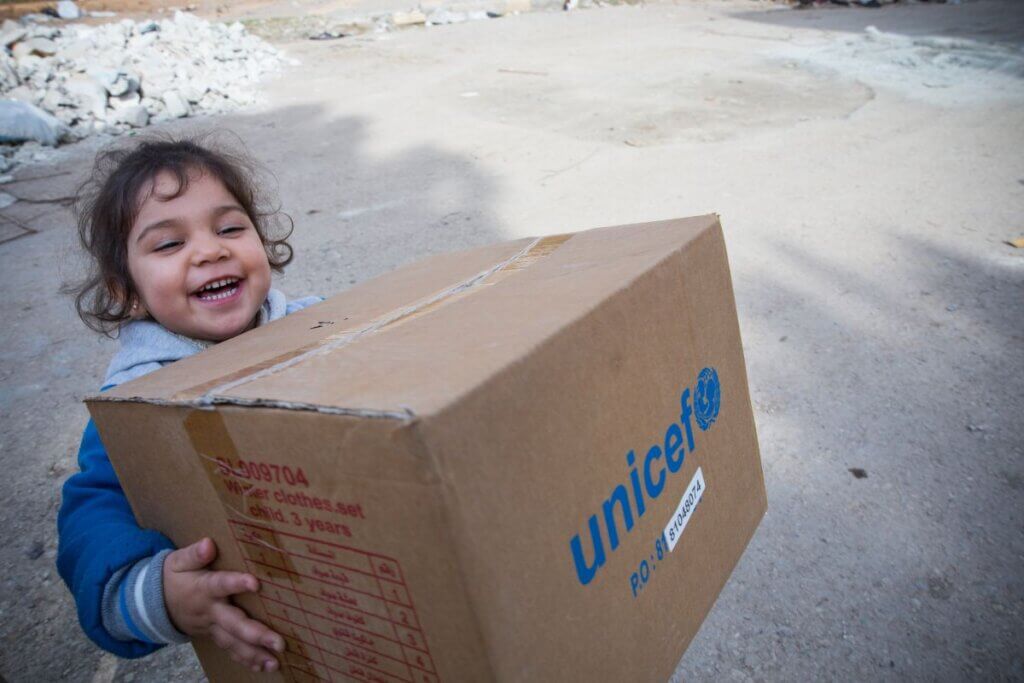 Vesel otrok nese UNICEF-ov paket