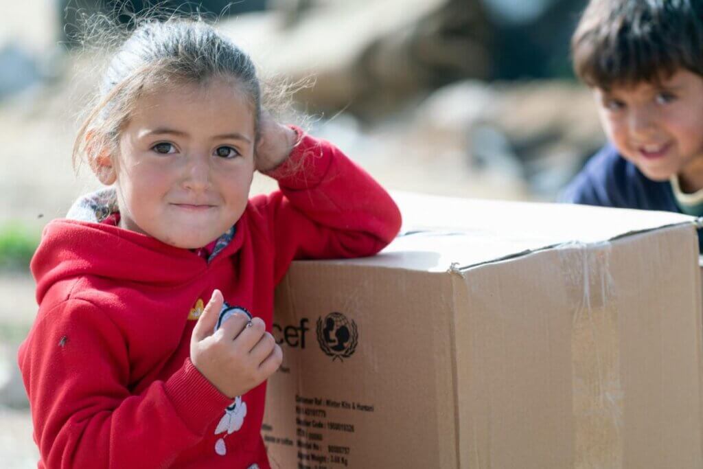 Vesela deklica sloni na UNICEF-ovem paketu