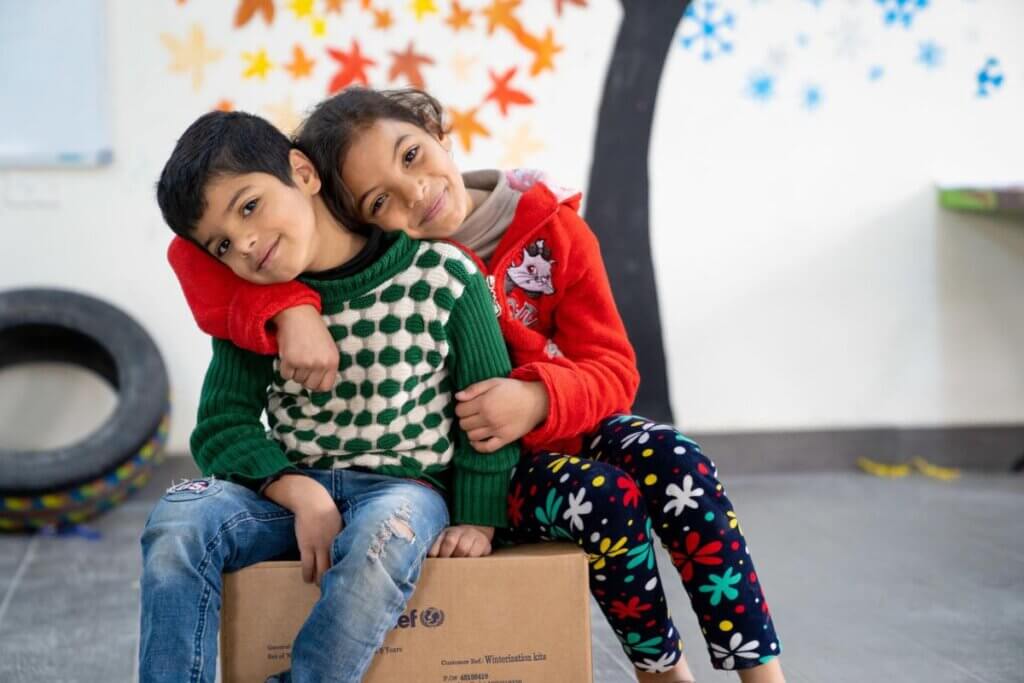 Brat in sestra sedita na UNICEF-ovem paketu