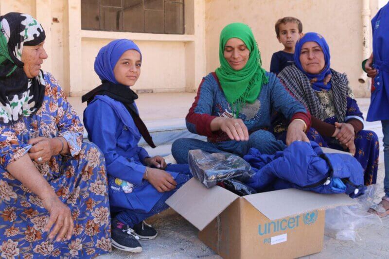 Mati in hčer si ogledujeta UNICEF-ov paket zimske opreme