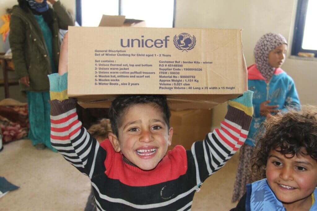 Vesel fant nad glavo drži UNICEF-ov paket