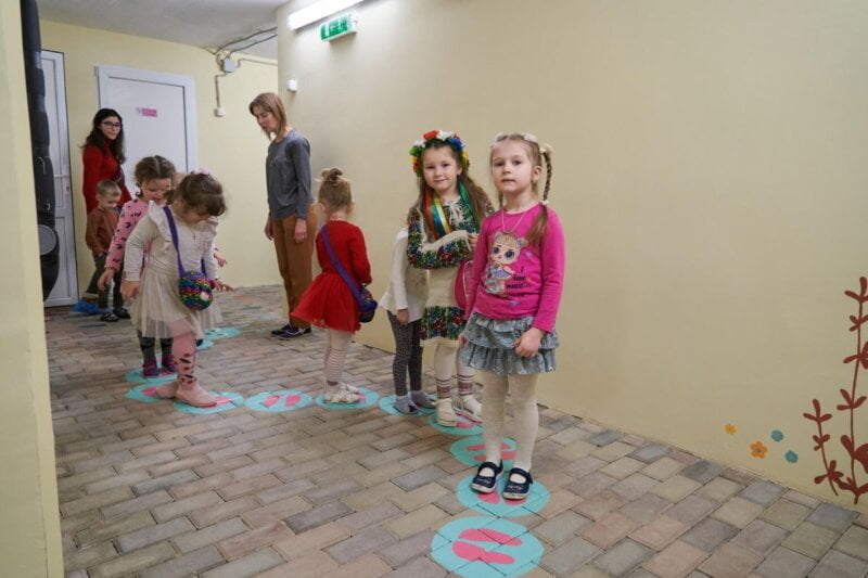 Otroci se igrajo na hodniku pred zakloniščem.