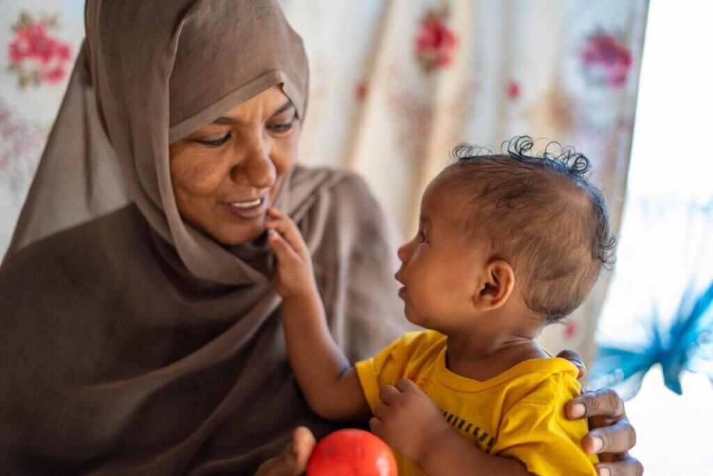 Sabna Mohamed iz Sudana med igro s svojo 9-mesečno hčerko Fatumo.