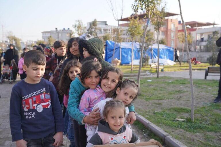 Otroci, ki so jim potresi poškodovali ali uničili domove, čakajo v vrsti za hrano, topla oblačila in odeje v provinci Hatay v Turčiji.