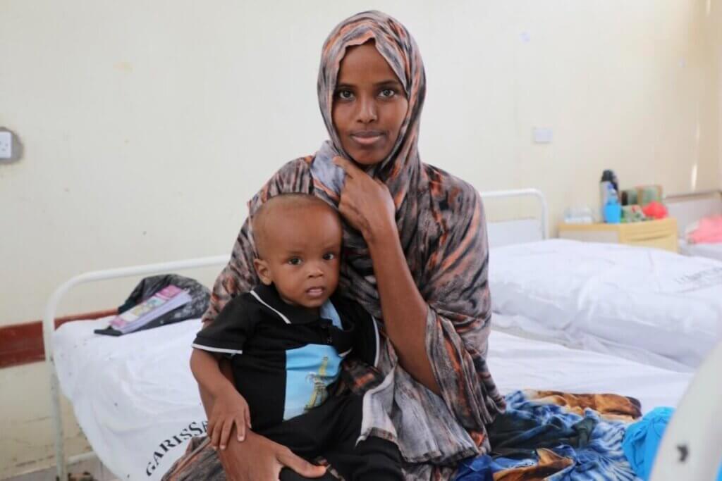 10-mesečni Mansuur Osman v stabilizacijskem centru v okrožju Garissa v Keniji počiva v materinem naročju.