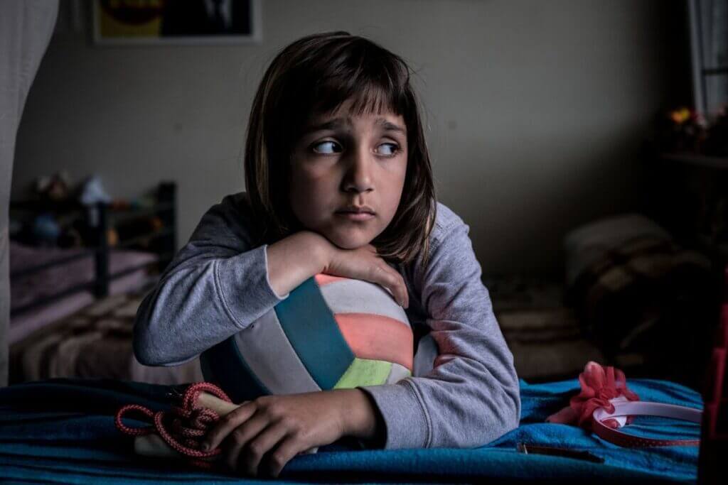 8-letna Mahi Omar sedi v svoji sobi v zasilnem stanovanjskem naselju v begunskem taborišču, ki se nahaja v predmestju Berlina, Nemčija.