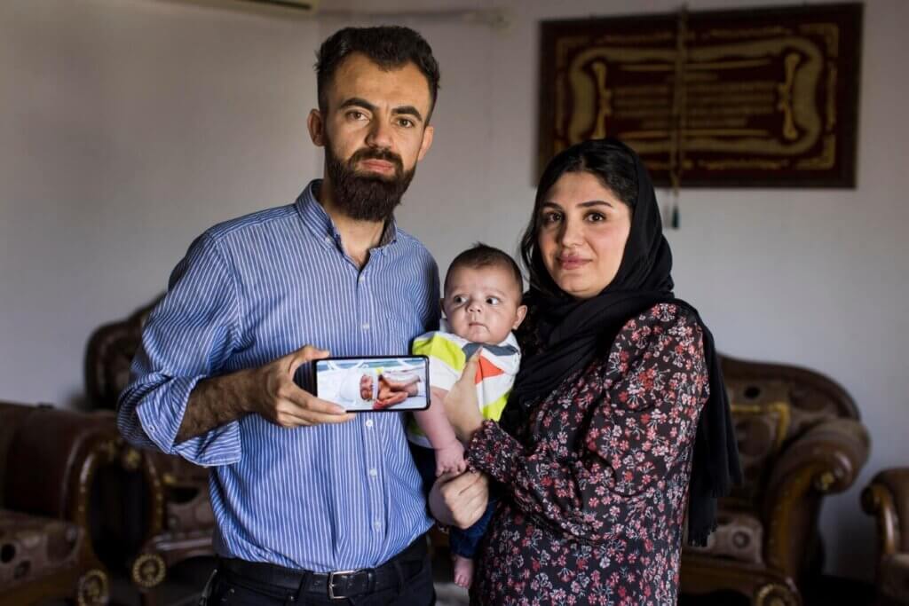 Starša kažeta fotografijo svojega 6-mesečnega sina Mohammeda, ko je bil v inkubatorju.