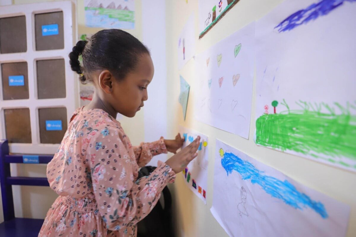 Deklica, ki je narisala risbo v otrokom prijaznem prostoru v Egiptu.