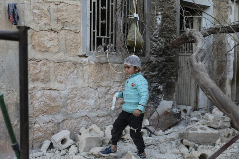 6-letni Musa iz Sirije stoji pred svojo hišo, ki jo je poškodoval potres.