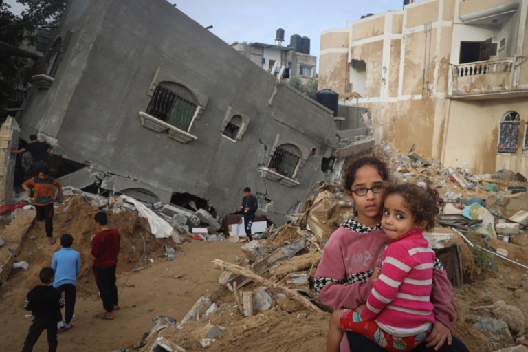 12-letna Abeer drži svojo 4-letno sestro Zahro pred njihovo porušeno hišo v Rafi na jugu Gaze.