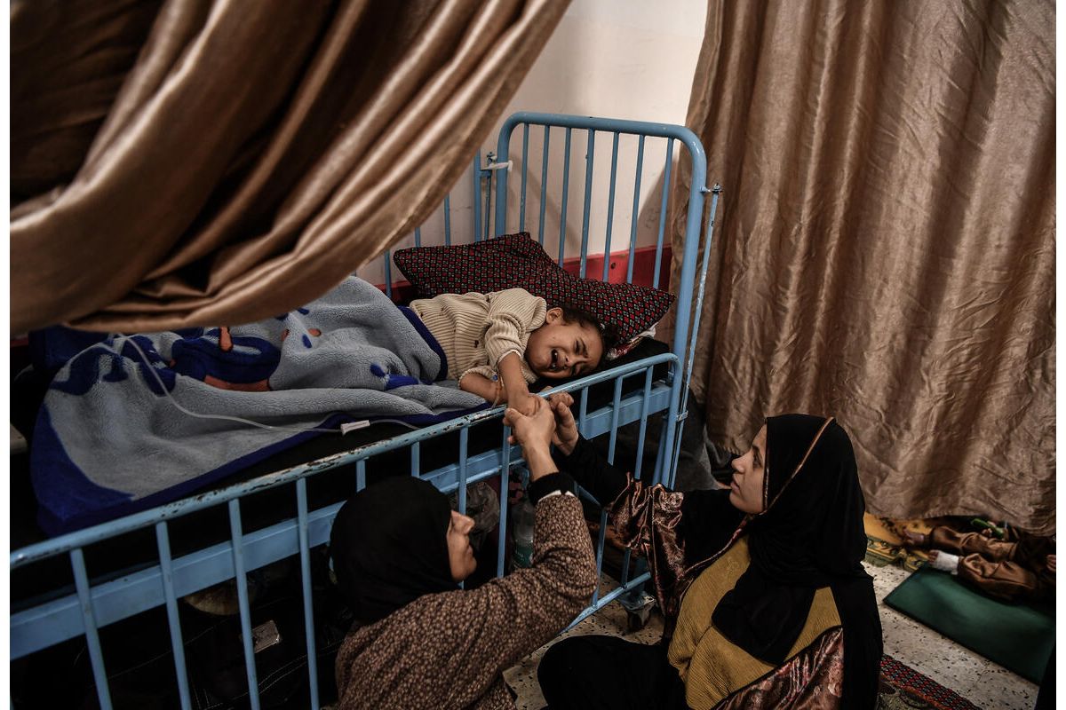 Mama in babica tolažita deklico Ghazal, ki je utrpela težko poškodbo noge in se bo kmalu morala soočiti s kruto realnostjo-življenjem brez noge.
