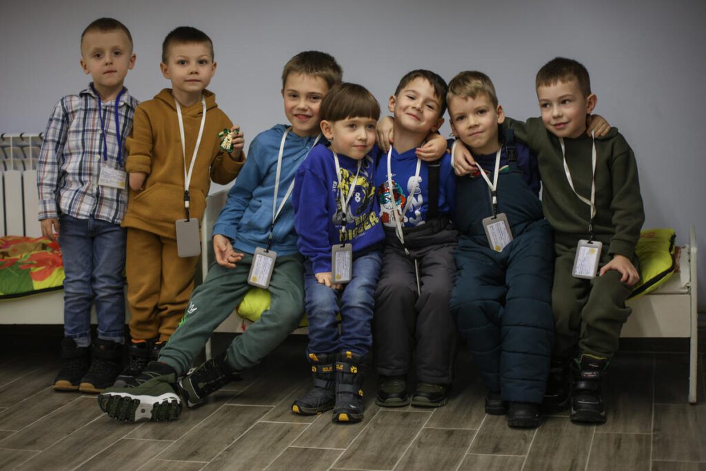 Skupinska fotografija predšolskih dečkov v zavetju njihovega vrtca v Žitomiru. Med zračnimi napadi se lahko otroci zatečejo v podzemne prostore vrtca in nemoteno nadaljujejo z vsakdanjimi aktivnostmi.