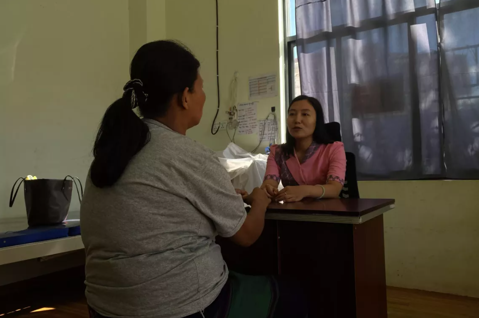 Daw Lai na svetovanju pri Ma Seng, izvajalko psihosocialne podpore na nosečniški kliniki v Mitkjini, Mjanmar.
