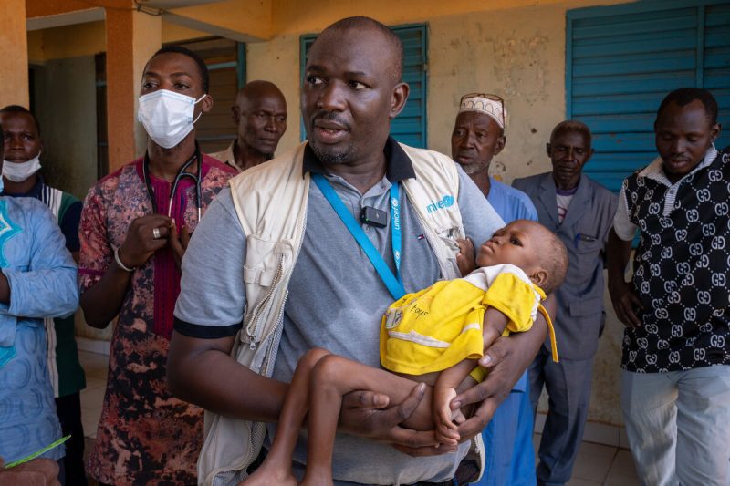 UNICEF-ov sodelavec drži 2-leti staro Aminato, ki je videti v zelo slabem stanju.