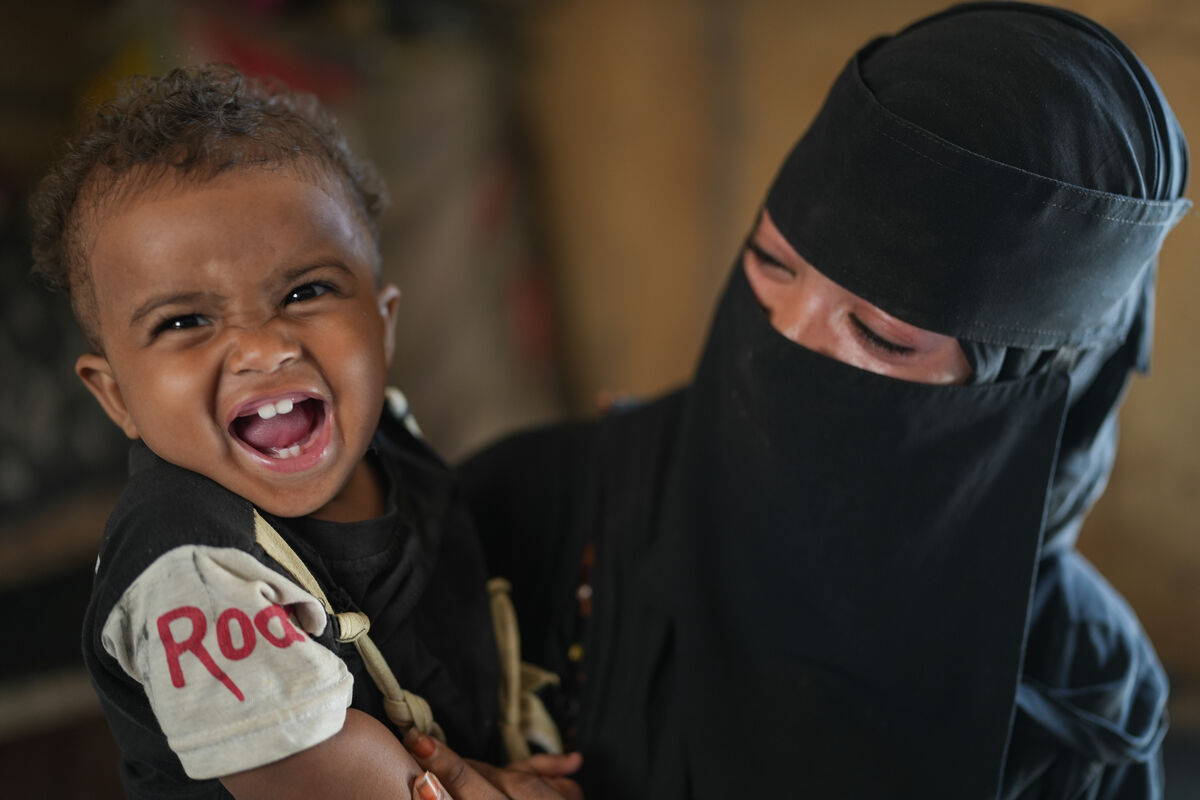 Fotografija malega Sanada iz marca 2024, ko se zdrav in nasmejan ozira v kamero - po tem, ko je uspešno premagal hudo akutno podhranjenost.