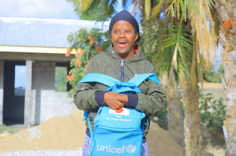 Fierdos iz Etiopije se smeji kameri z UNICEF-ovim šolskim nahrbtnikom.