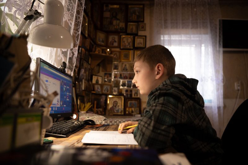 11-letni Tymofii se osredotoča na uro matematike, medtem ko se uči prek spleta od doma.
