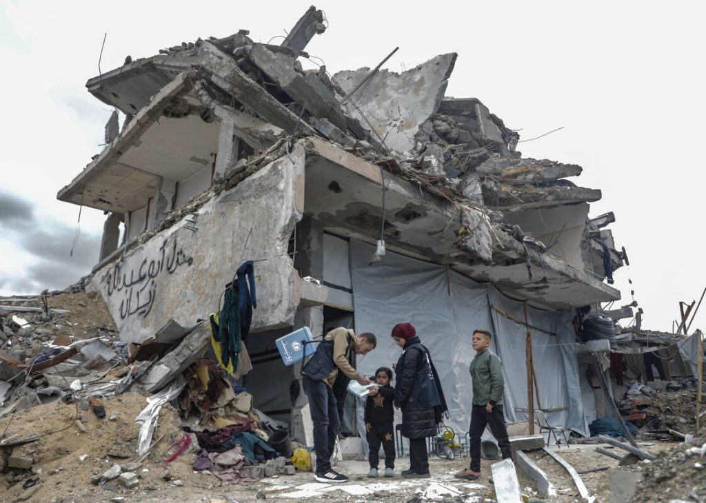 Otroci prejemajo cepivo proti otroški paralizi v Jabaliji severno od Gaze pred razbito hišo.