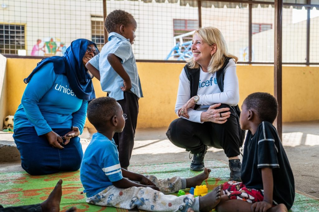 Izvršna direktorica UNICEF-a Catherine Russell se druži s 4-letnim Ahmedom na igralnem senčniku v centru za ženske in dekleta Jembia v zvezni državi Kassala.