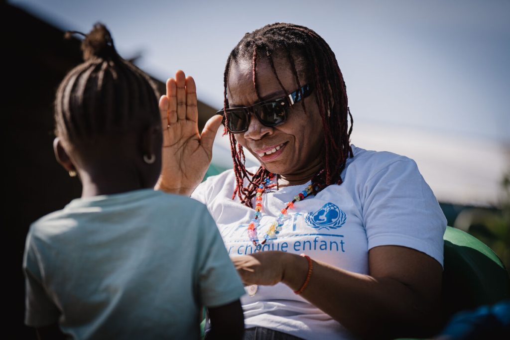 Wyvine Lufungulo, uradnica UNICEF-a za izobraževanje, se 27. novembra 2025 pred svojo hišo v Bunii, DR Kongo, igra z Grace*, 6-letno deklico.