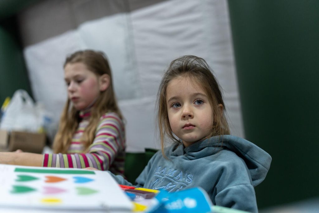  Štiriletna Mila iz Kijeva v Ukrajini se igra v ogrevanem šotoru, ki ga je vzpostavila Državna služba za izredne razmere Ukrajine, 18. januarja 2026.