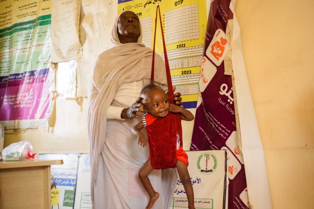 1-letna podhranjena deklica Mawada med pregledom v zdravstvenem centru Dar Al-Salam v Port Sudanu. Na fotografiji jo zdravnica tehta.