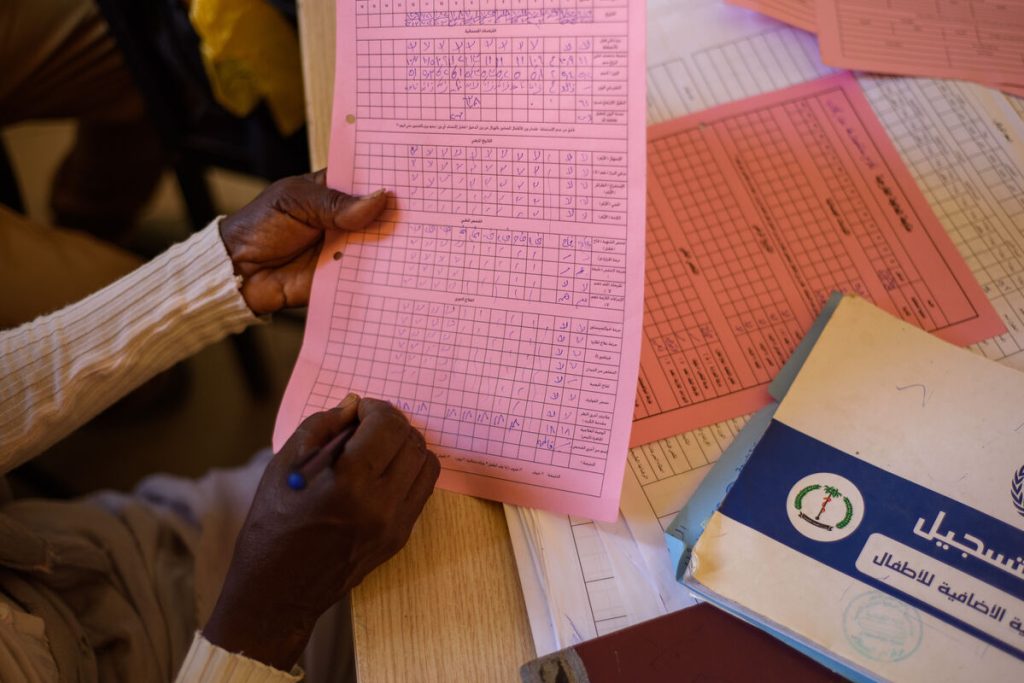 Jawahir Bashir Ahmed, strokovnjakinja za prehrano, v zdravniški karton vnaša podatke o otrocih, ki obiskujejo terapevtski program za ambulantno zdravljenje, ki ga podpira UNICEF, v zdravstvenem centru Dar Al-Salam v Port Sudanu.