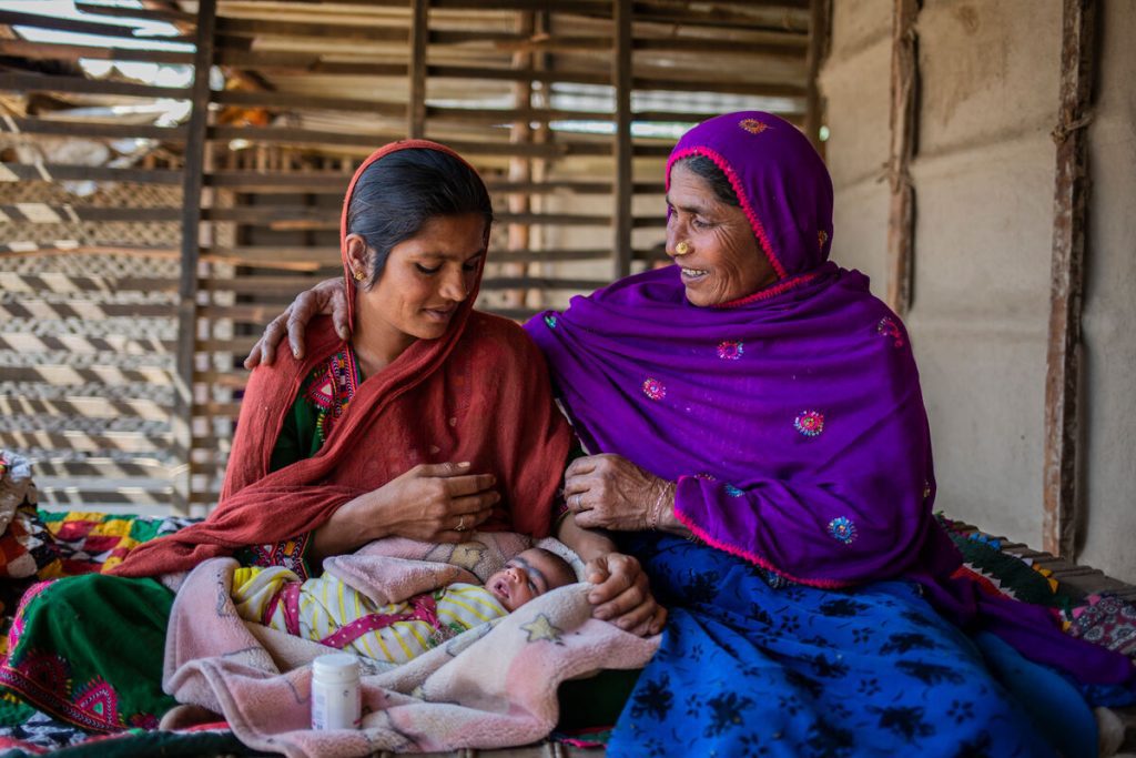 Rozan, ki se je rodila gluha, sedi v mestu Thatta v provinci Sindh, v Pakistanu skupaj s svojo taščo Nooran, v naročju drži svojega otroka.