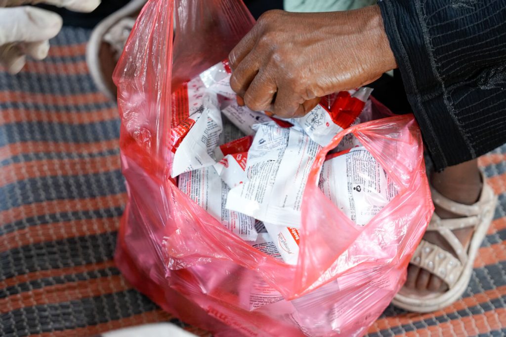 V taborišču za notranje razseljene osebe Al-Atira v Lahju pripravljajo plastično vrečko, napolnjeno z vrečkami terapevtske hrane za takojšnjo uporabo (RUTF), za razdeljevanje.