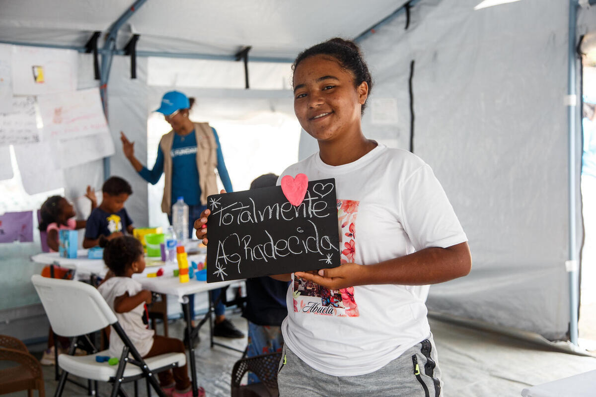 16-letna Gabriela iz Venezuele v UNICEF-ovem varnem prostoru drži svojo risbo.