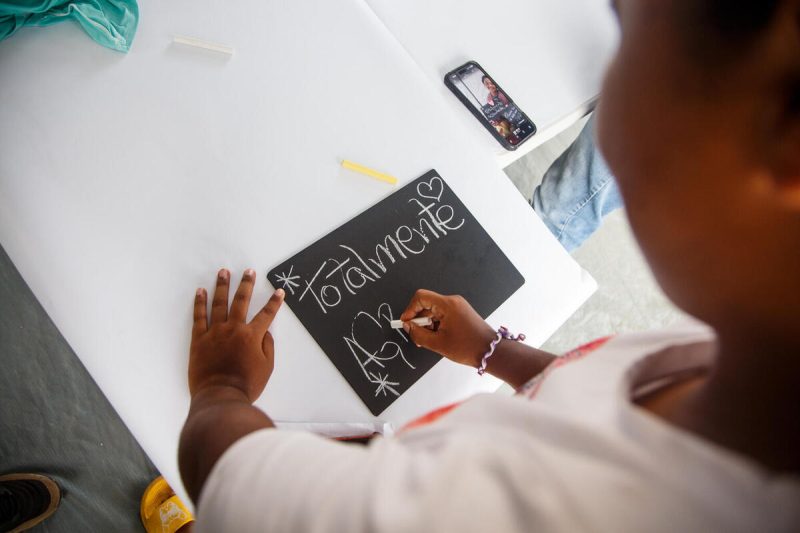 16-letna Gabriela iz Venezuele v UNICEF-ovem varnem prostoru piše na tablo.