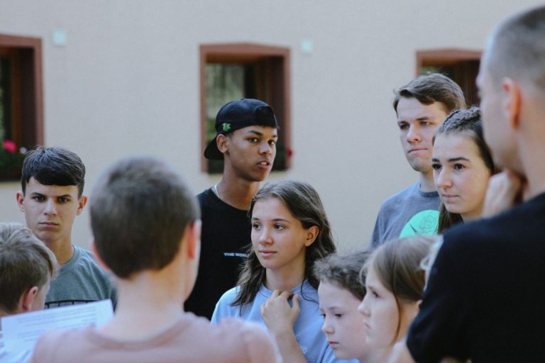 Najstniki, zbrani na prostem, so se živahno pogovarjali.