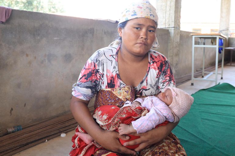 29-letna Nanu Maya drži v naročju svojega 13 dni starega dojenčka v šolskem zatočišču v poplavljenem Nepalu.