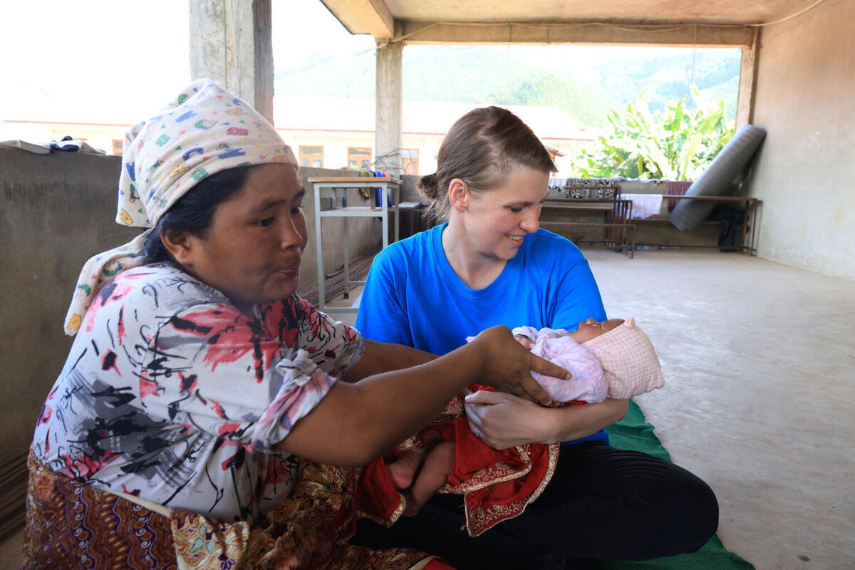 Nanu Maya drži v naročju svojega novorojenega sina, ob njej pa stoji vodja oddelka za komunikacijo pri UNICEF-u v Nepalu, v šolskem zatočišču v okrožju Nuvakot, ki ga je prizadela poplava.