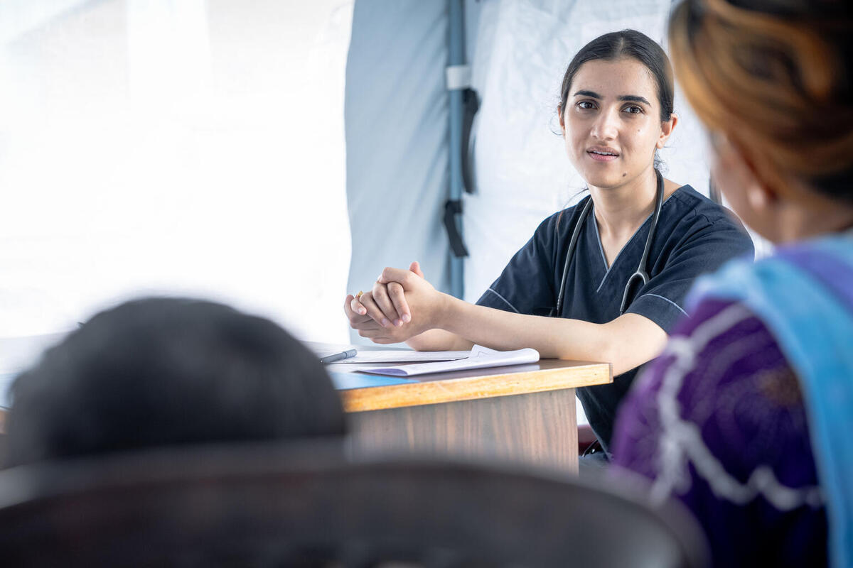 Dr. Shitanshu Dhakal se pogovarja v zdravstvenem šotoru v Nepalu, ki ga podpira UNICEF.