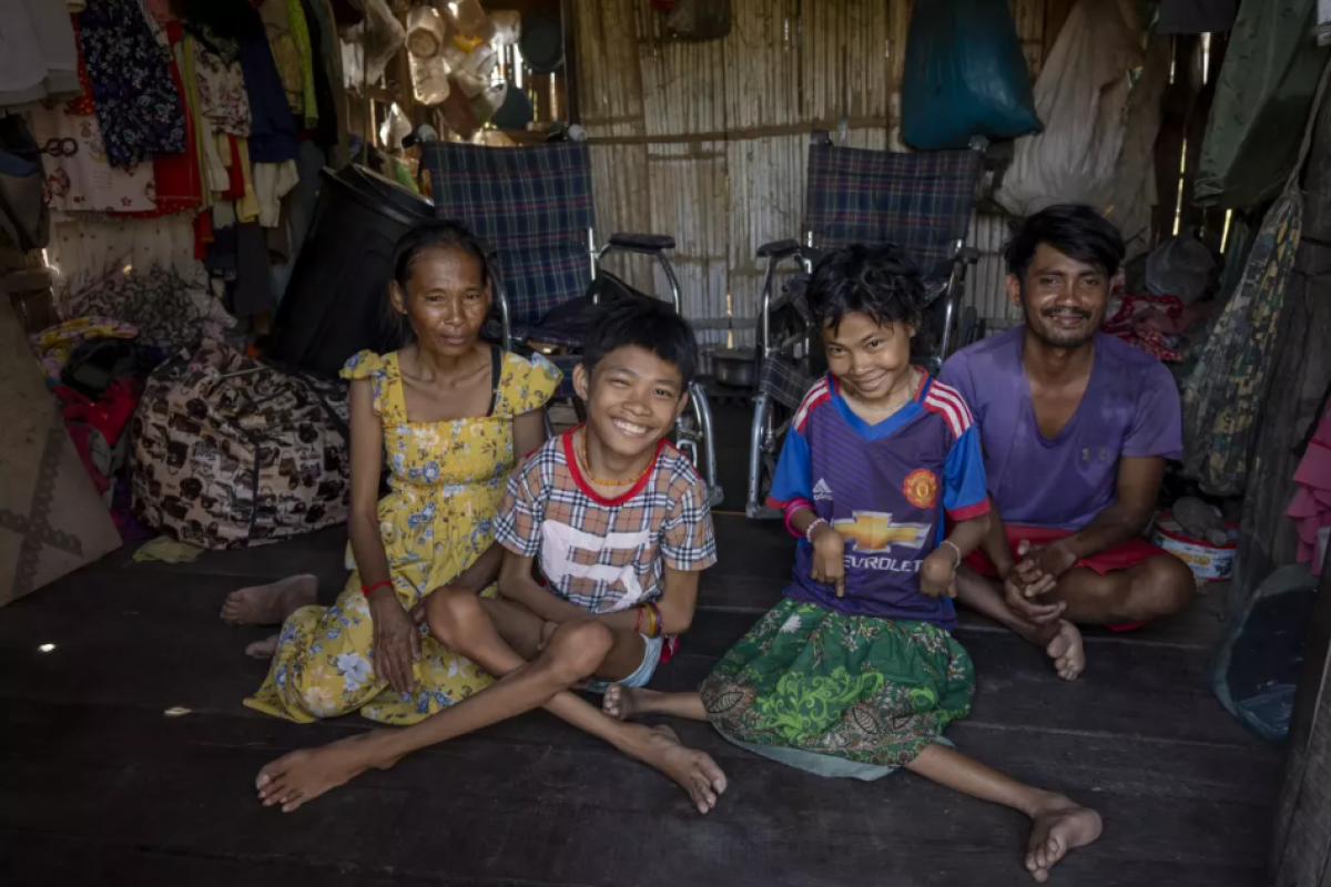 Družina 29-letnega ribiča iz Kambodže sedi doma in se smeje kameri.