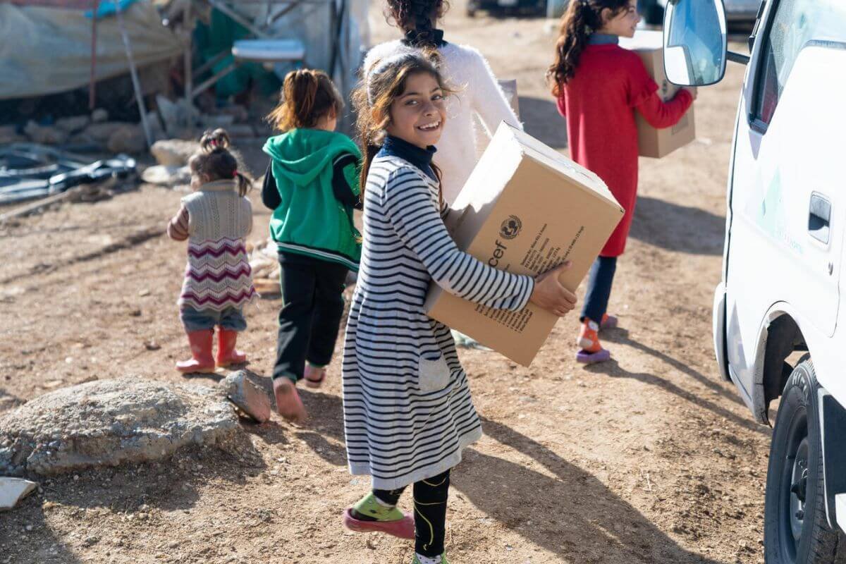 Vesel otrok nosi UNICEF-ov paket