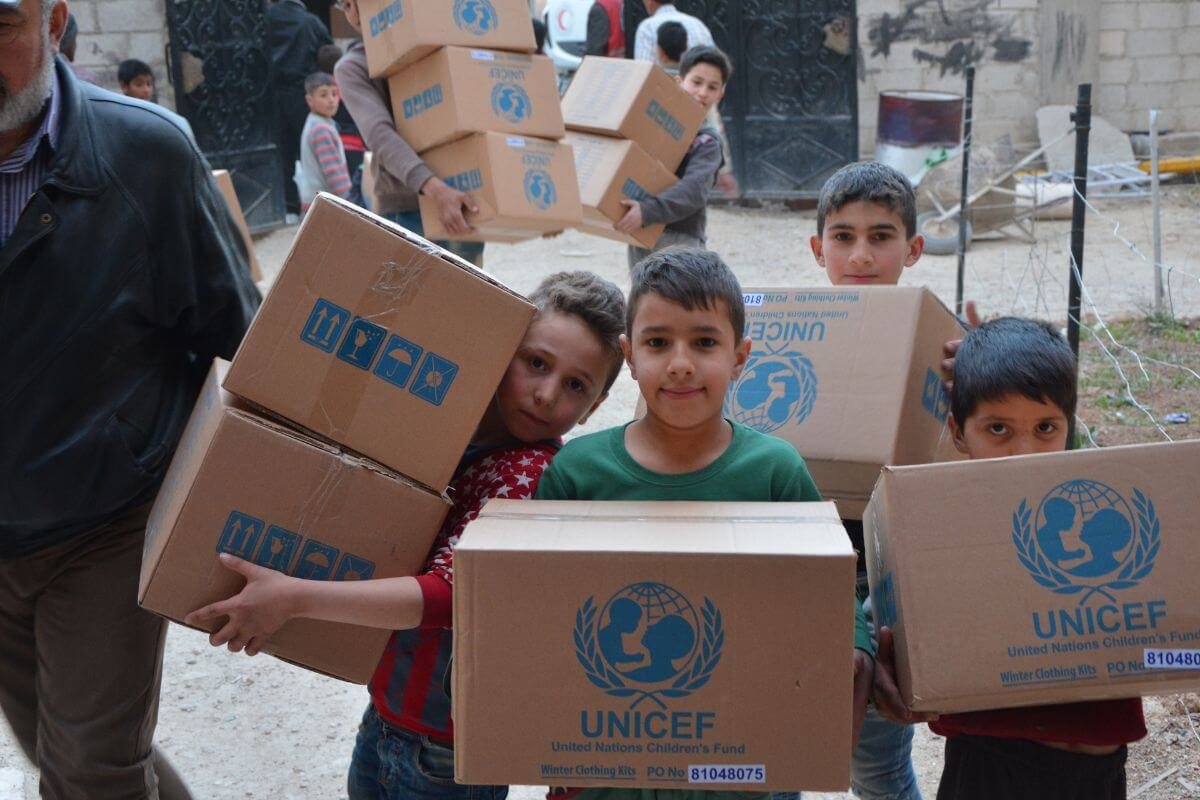 Otroci nesejo UNICEF-ove pakete