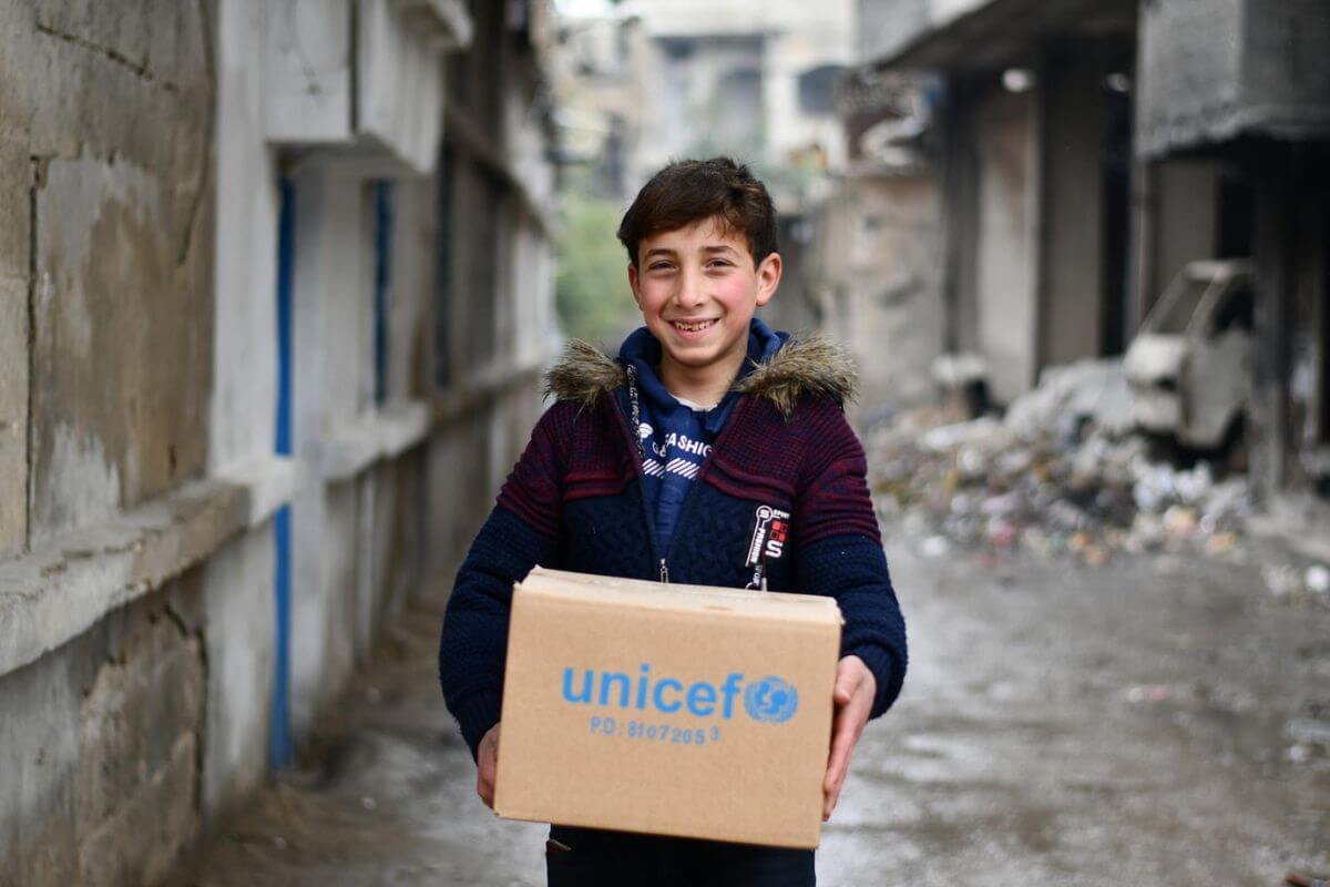 Vesel otrok drži UNICEF-ov paket