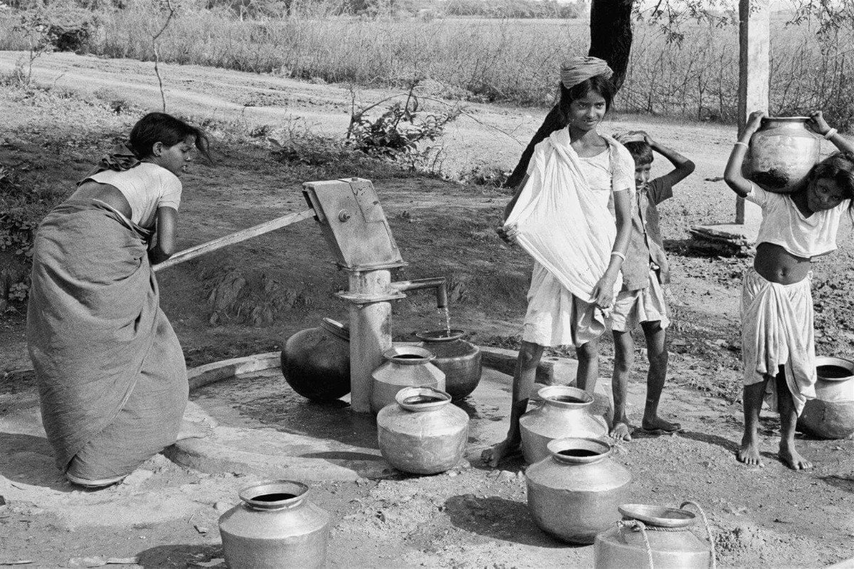 Otroci črpajo vodo s pomočjo črpalke