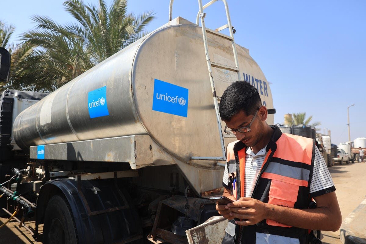 Delavec pred UNICEF-ovim rezervoarjem vode v Deir al-Balahu v Gazi. Rezervoar je omogočen s podporo partnerjev.