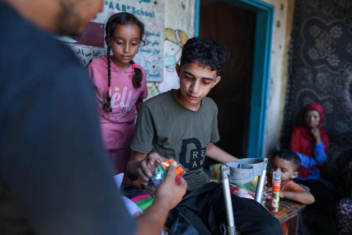 Jihad, 17-letnik, ki je zaradi vojne izgubil nogo in bil prikrajšan za pravico do izobraževanja, prejema UNICEF-ov komplet psihosocialne pomoči (PSS komplet) na severu Gaze, zahvaljujoč podpori vlad Švice, Cipra in Švedske.