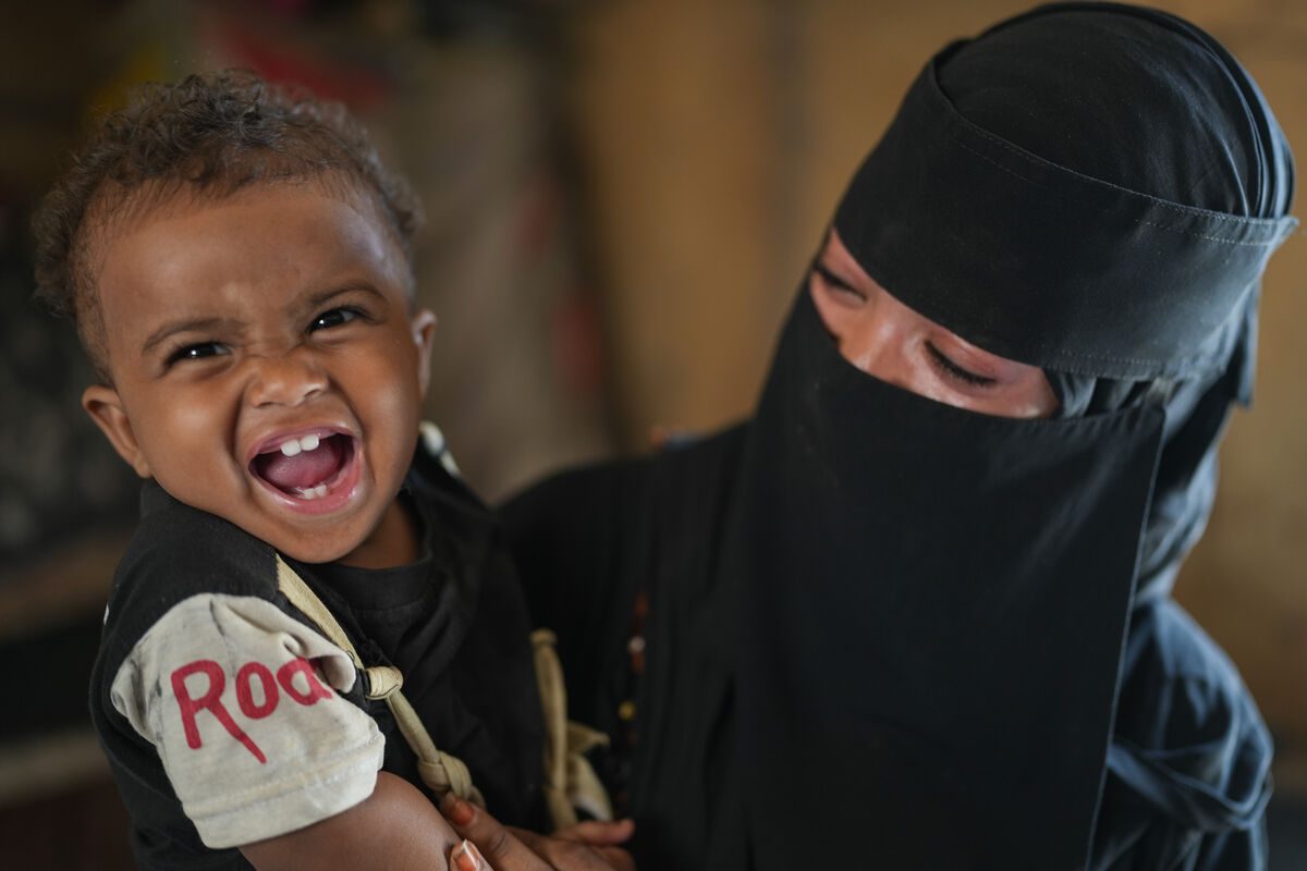 Fotografija malega Sanada iz marca 2024, ko se zdrav in nasmejan ozira v kamero - po tem, ko je uspešno premagal hudo akutno podhranjenost.