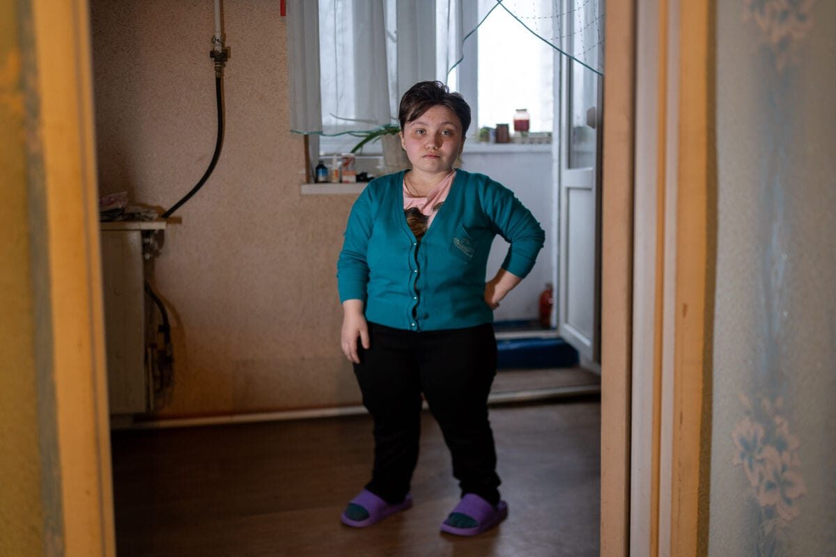 18-letna Darina stoji v majhnem stanovanju, ki si ga deli s svojimi skrbniki.