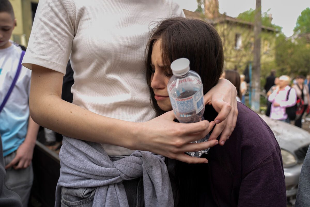 17-letno Viktorijo iz Ukrajine tolaži prijatelj, potem, ko je izvedela, da je bil njun 17-letni sopotnik po raketnem napadu najden mrtev pod ruševinami svojega doma.